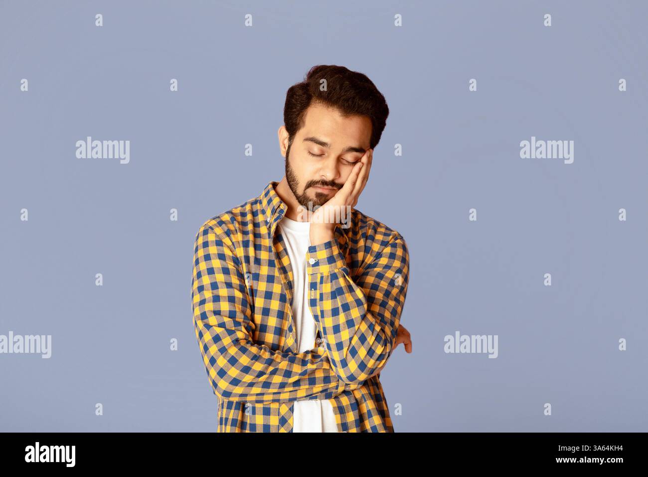 Tired Indian guy sleeping after overworking on lilac background Stock Photo