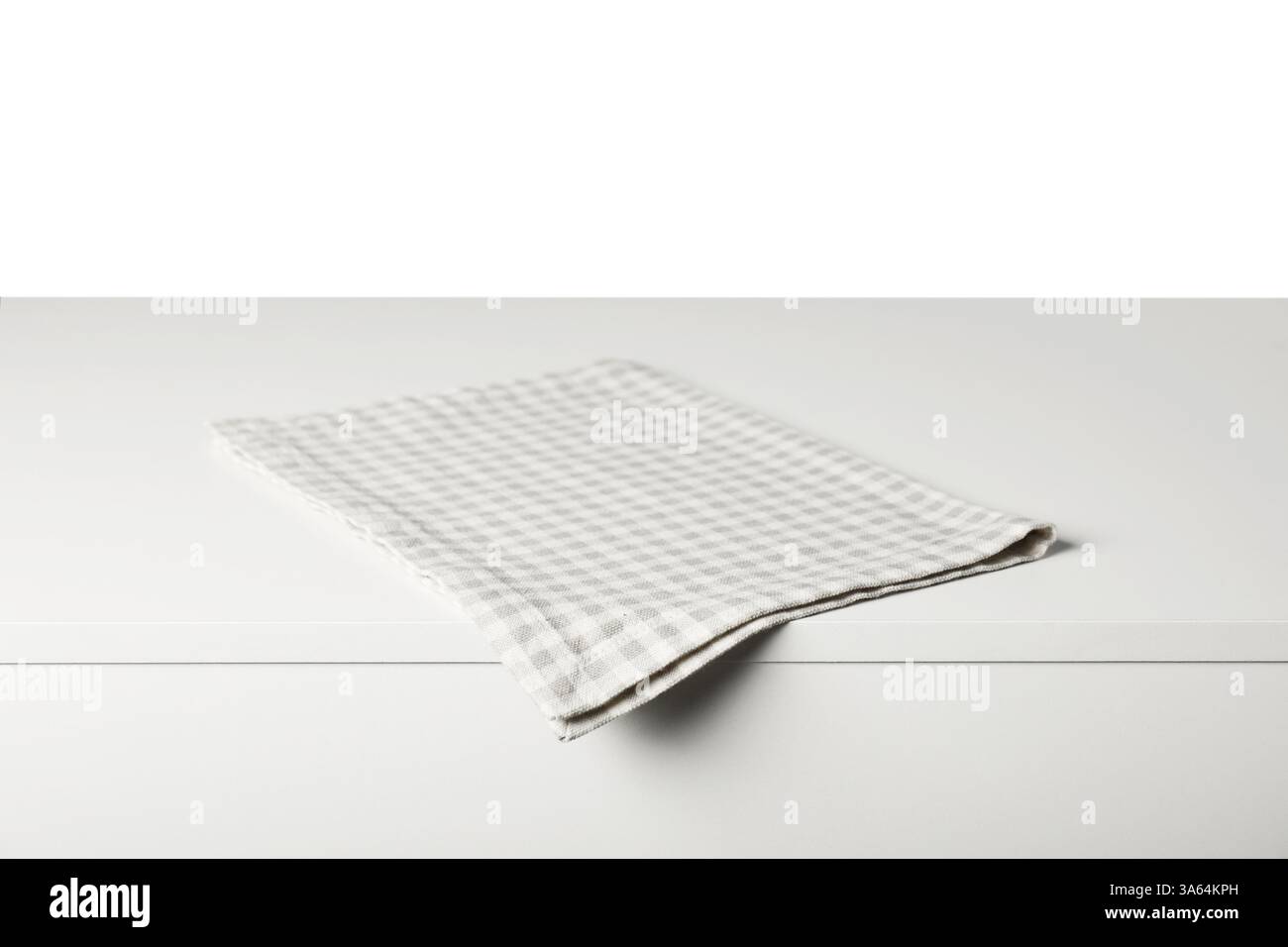 Checkered napkin on light table against white background Stock Photo