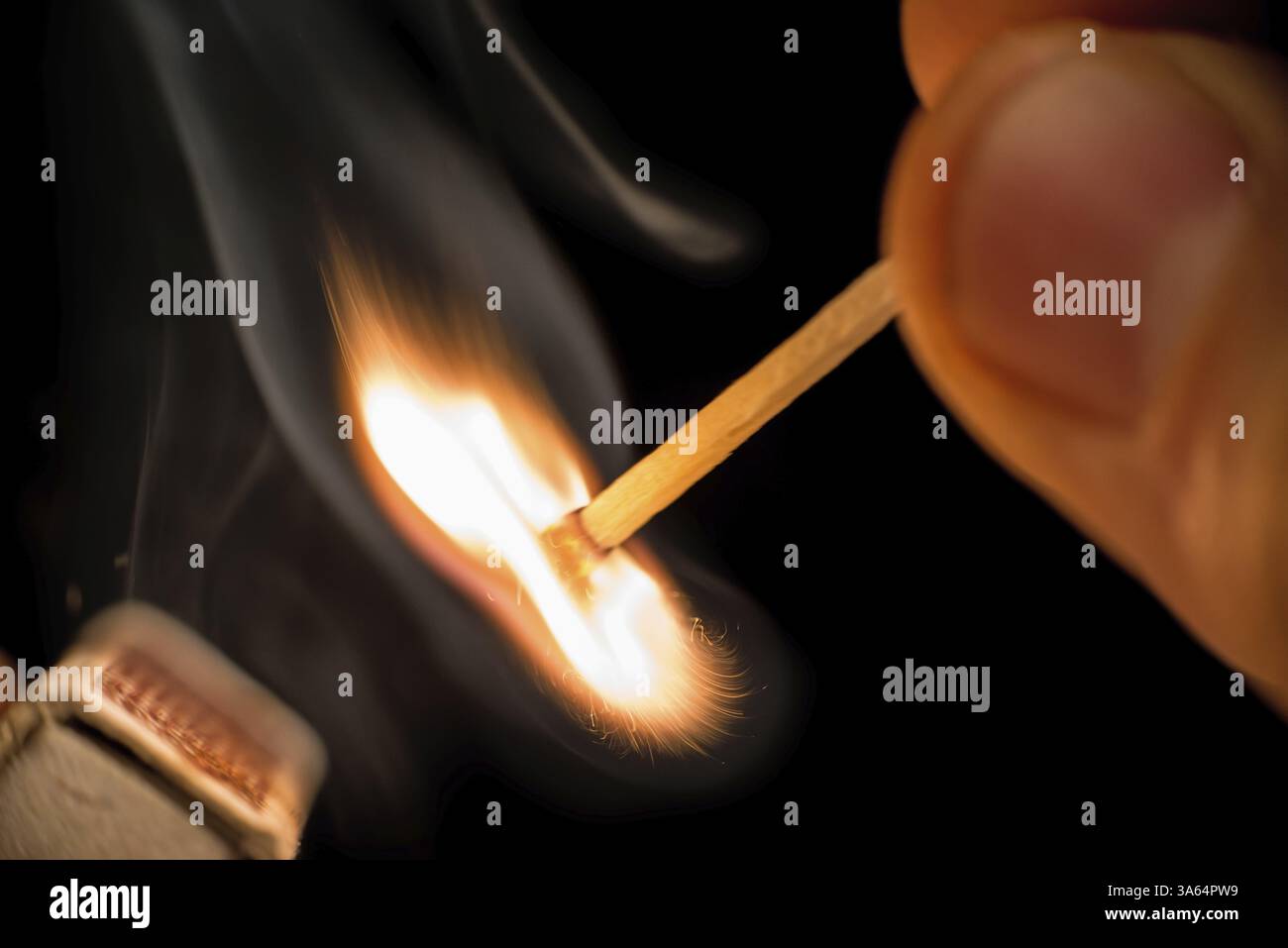 Fire from match in darkness. Hand holding match Stock Photo