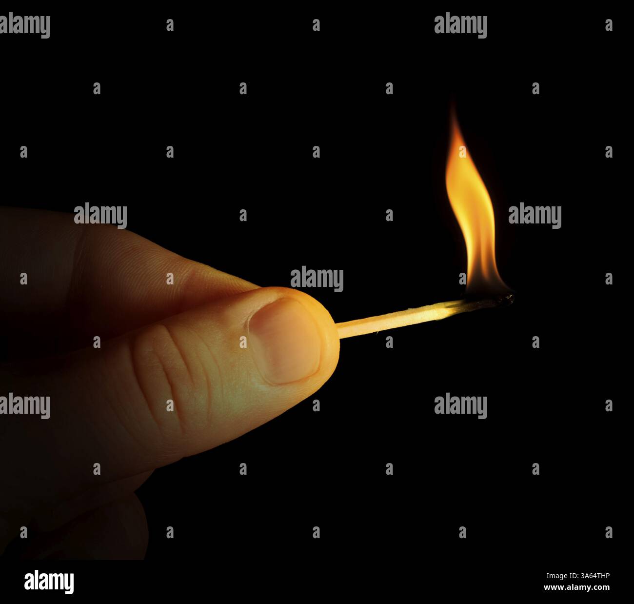 Hand holding burning match stick. Black isolated Stock Photo