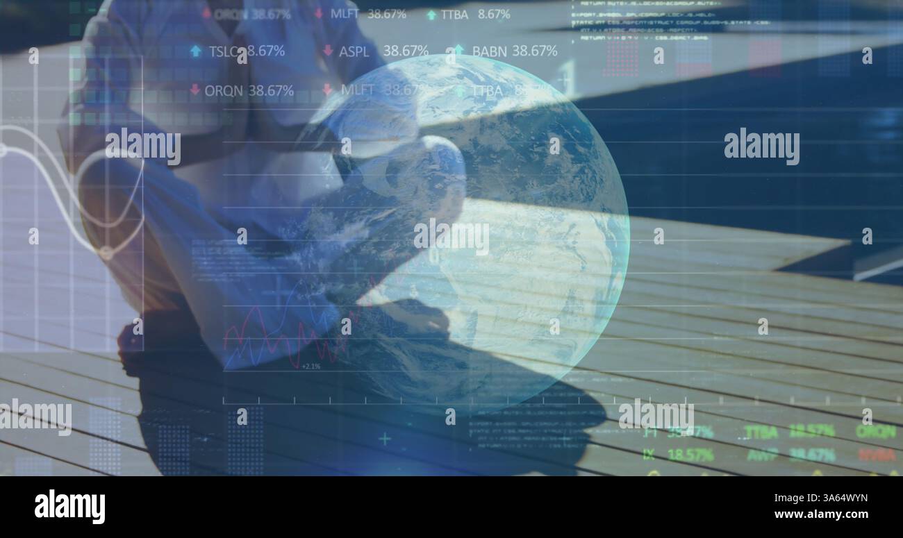 Person sitting on deck using laptop, analyzing global financial data trends Stock Photo