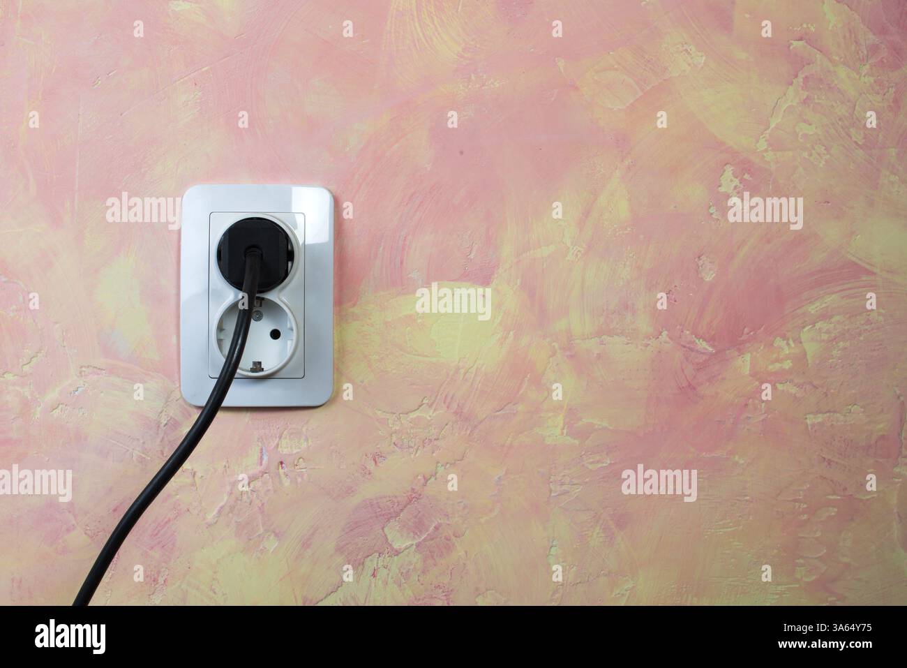 White socket and cable on pink wall. Double socket Stock Photo