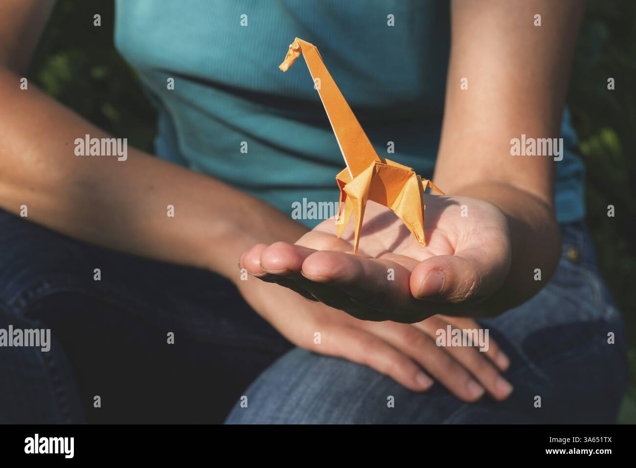 Origami orange color giraffe on hand Stock Photo