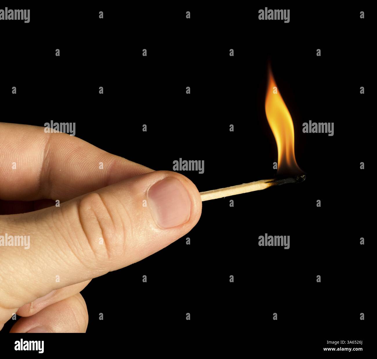 Hand holding burning match stick. Black isolated Stock Photo