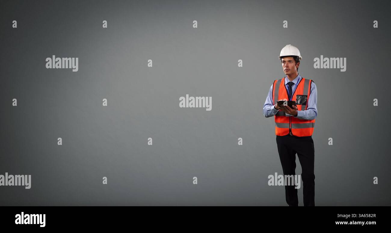 Construction engineer in hard hat and safety vest using tablet, focused on project Stock Photo