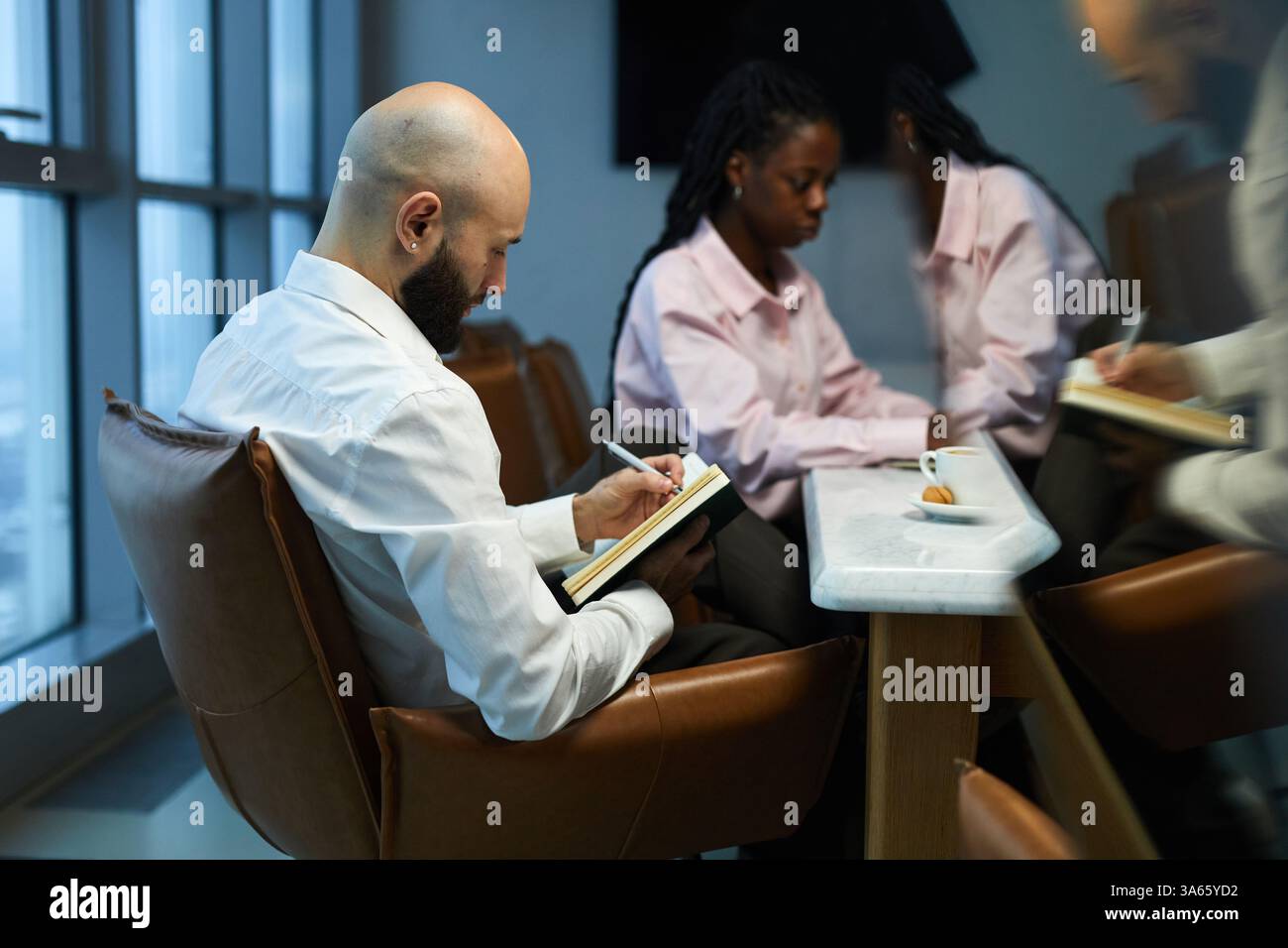 Businessman Making Notes At Meeting Stock Photo