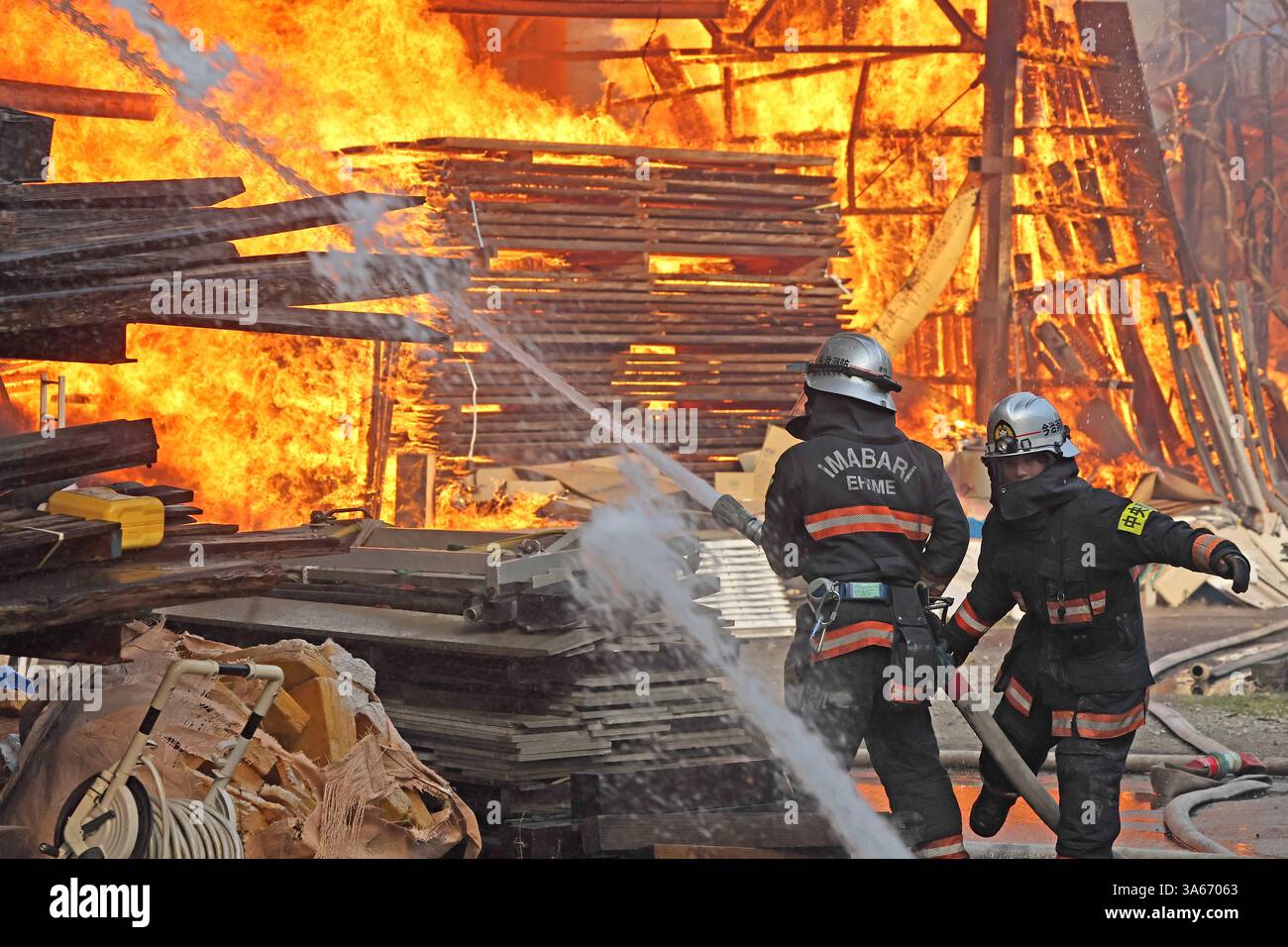 Firefighters struggle to extinguish the fire triggered by a wildfire in ...