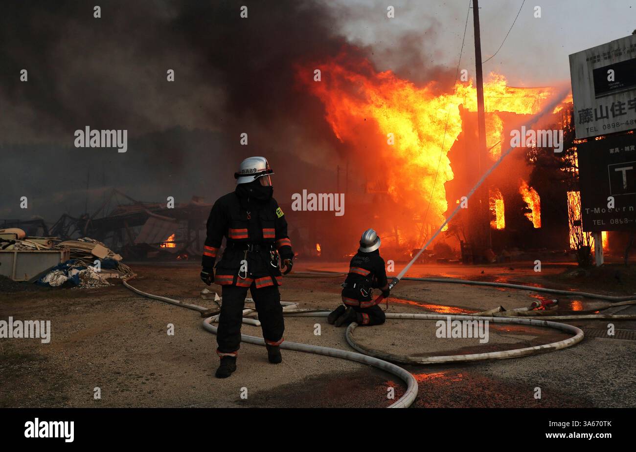 Firefighters struggle to extinguish the fire triggered by a wildfire in ...