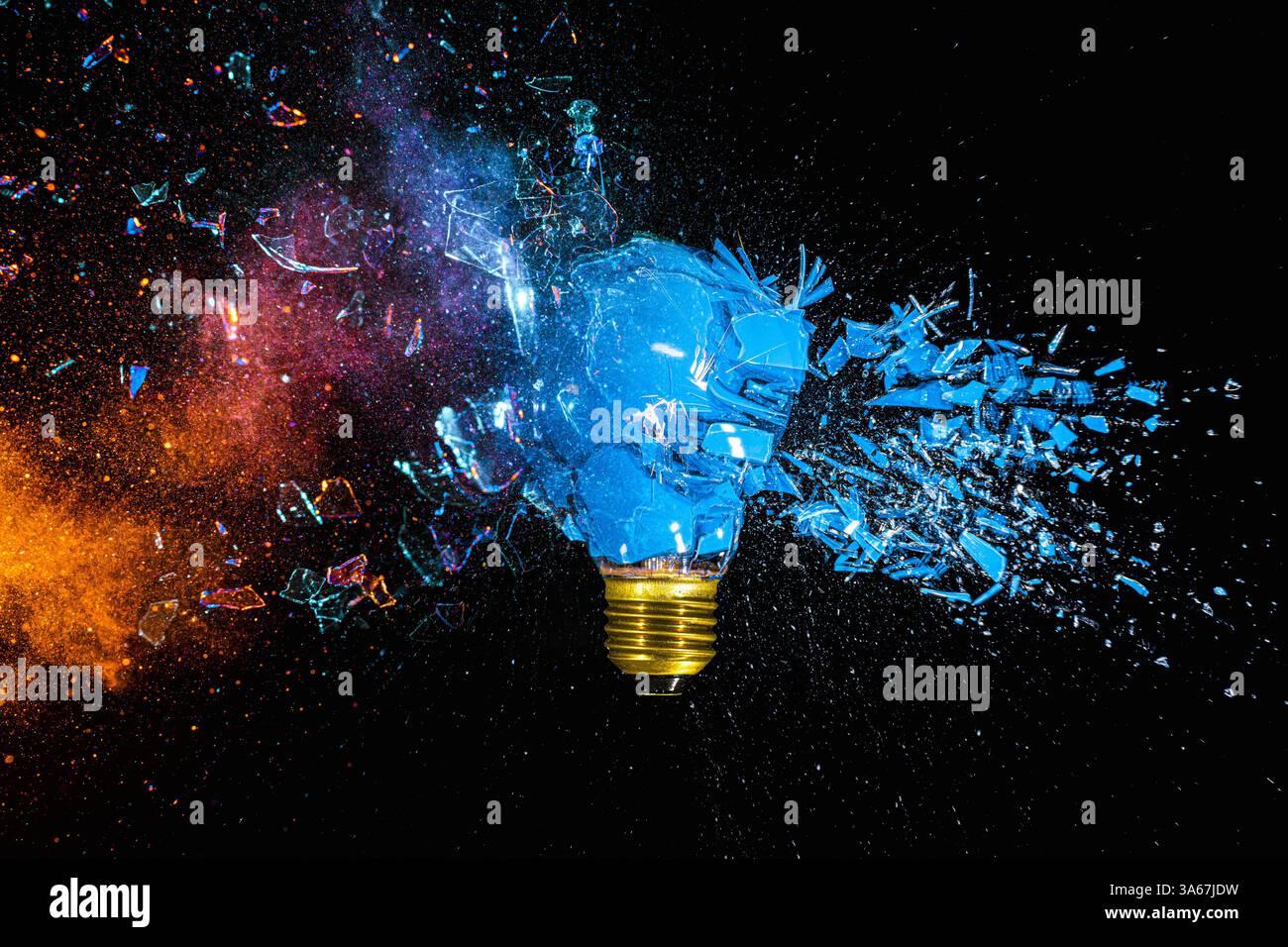 Blue lightbulb exploding on black background with colorful powder Stock Photo