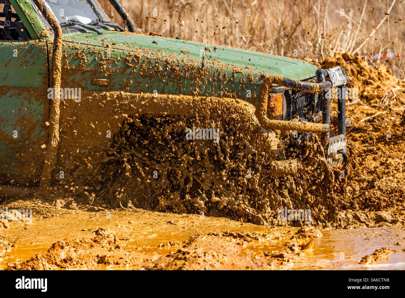 Off-road vehicle tires covered in mud and sand, car crossing a ditch ...