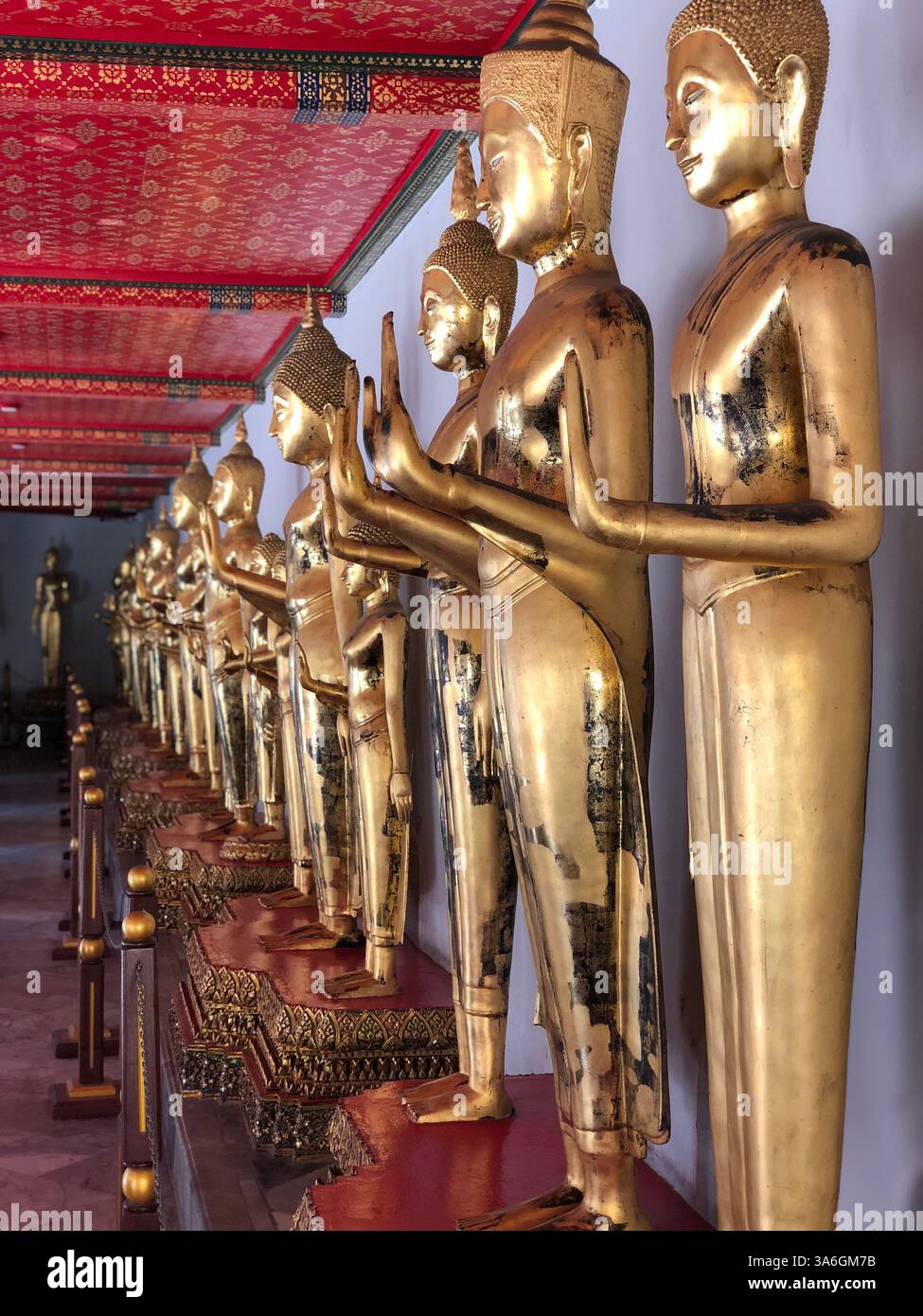 Wat Pho Temple (Bangkok, Thailand), Golden Buddha Statues in a row in a red hallway - Smartphone Captured Stock Image