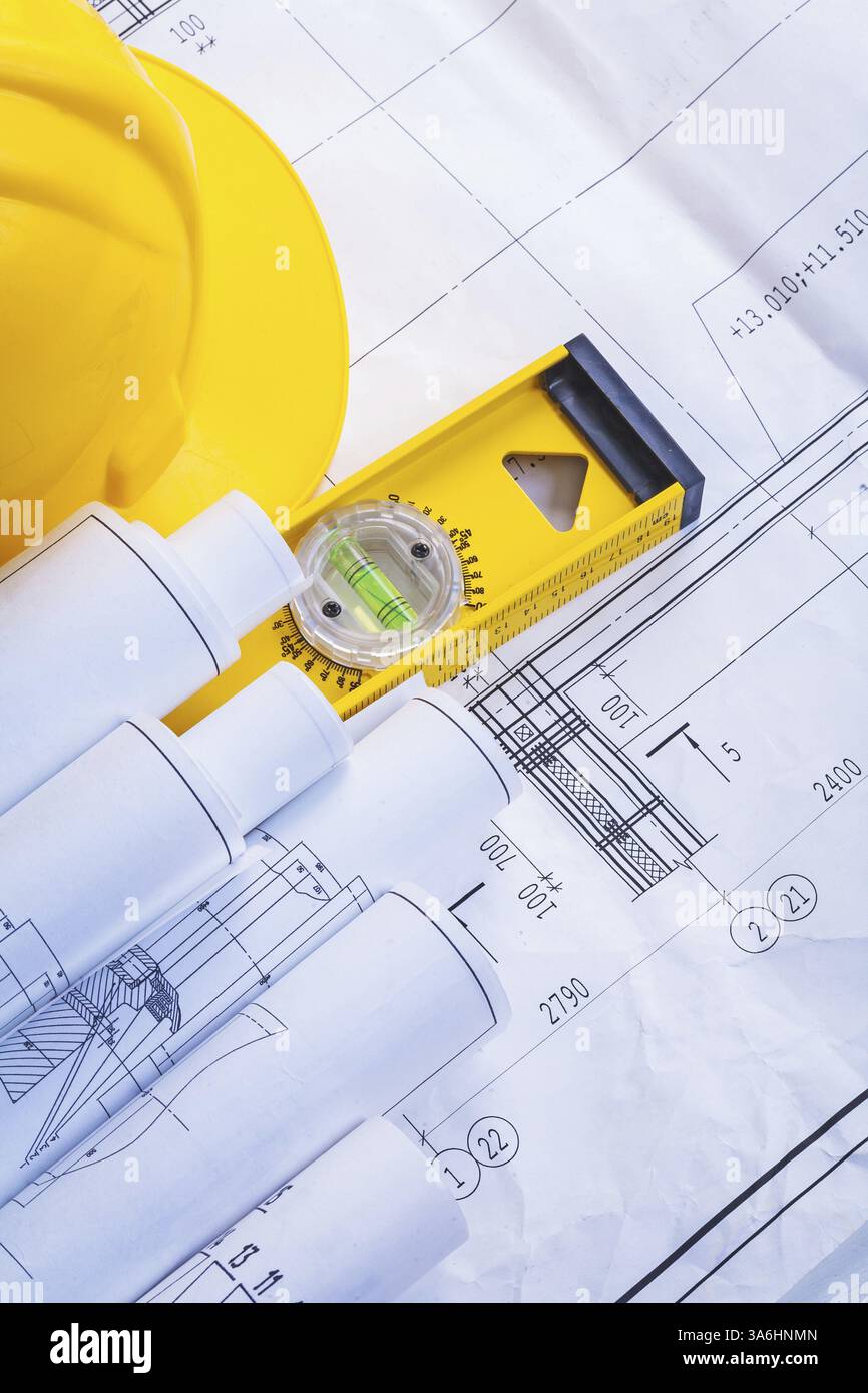 Construction level helmet rolled blueprints Stock Photo - Alamy