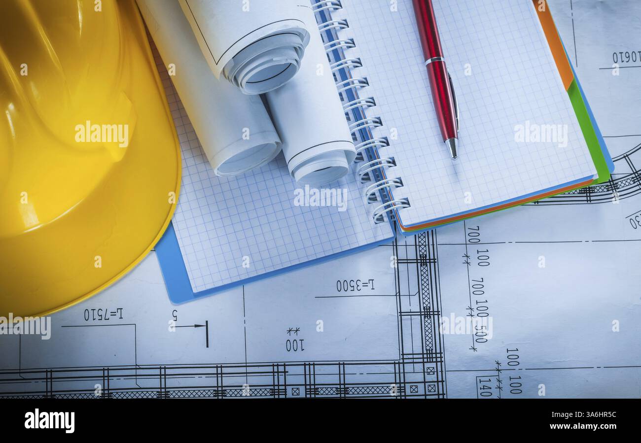 Safety hard hat checked notebook pen blueprints on construction plan Stock Photo