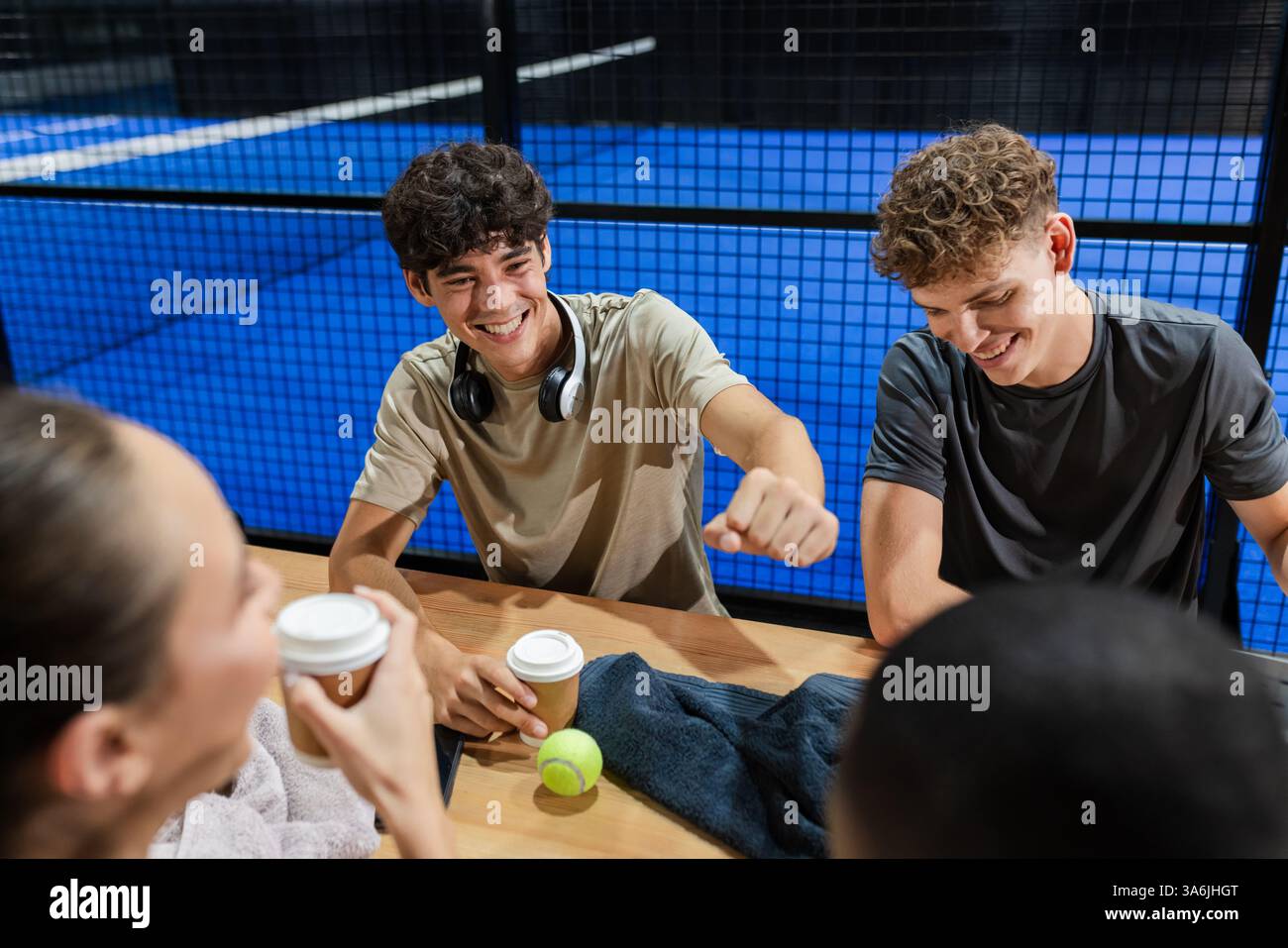 After padel tennis match, friends having coffee and chatting, smiling and relaxed Stock Photo