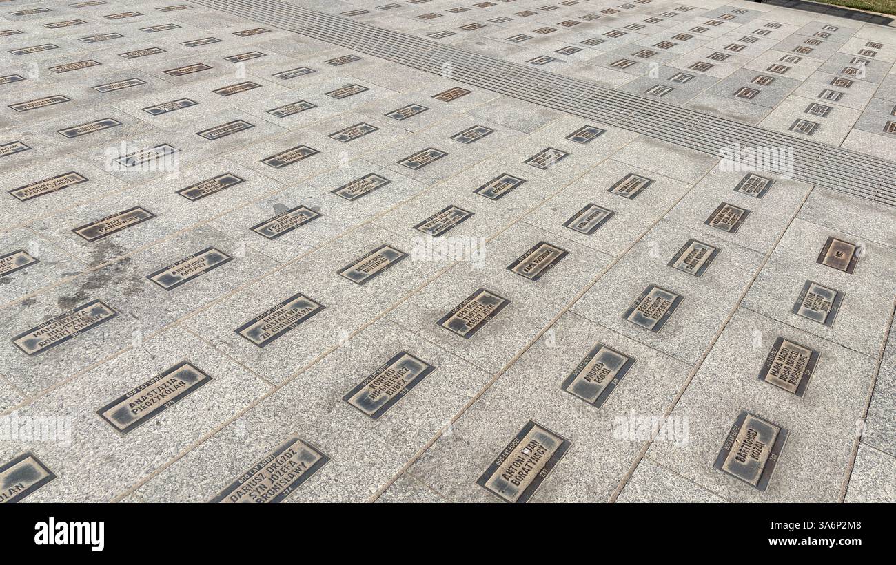 Sidewalk with bricks engraved with names near the Monument of Tadeusz Kościuszko. City urban street view in Lodz, Poland. Architecture, buildings and - Smartphone Captured Stock Image