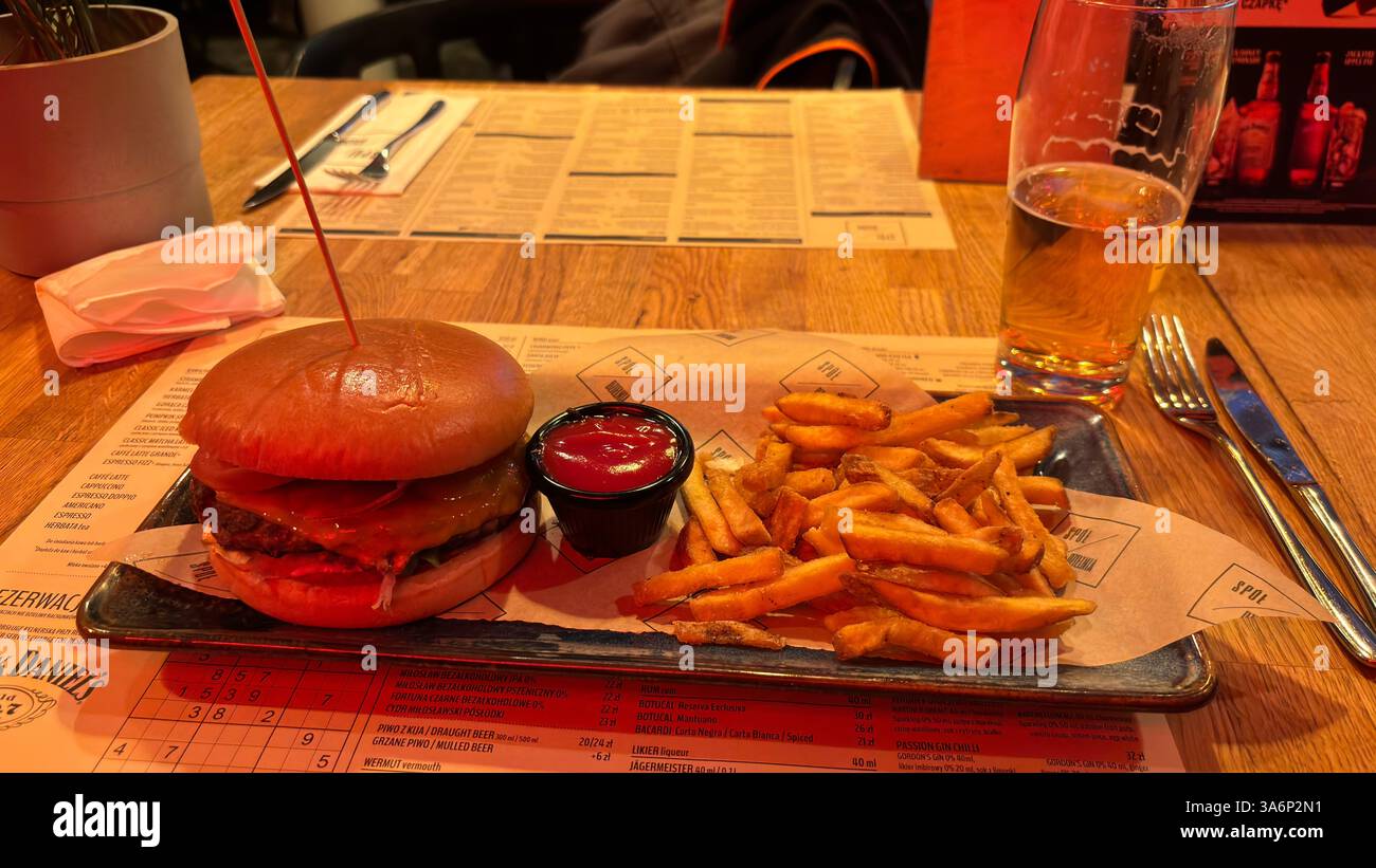 Large burger and fries in a trendy restaurant cafe. Fine dining designer chef food. Steak dinner with salad and chips - Smartphone Captured Stock Image