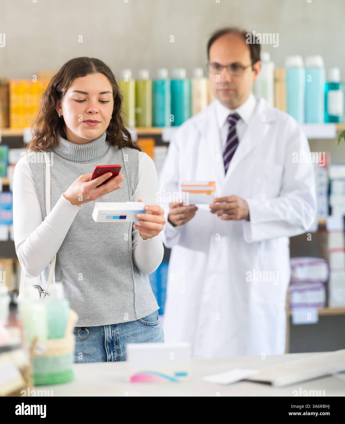 Woman buyer scans ointment qr code with man pharmacist Stock Photo - Alamy