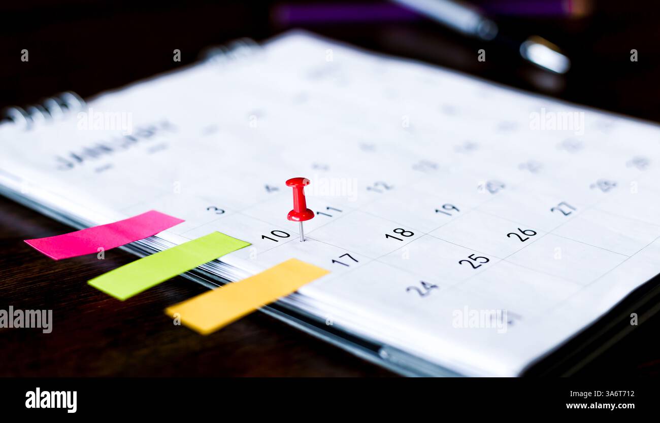 Embroidered pins on a calendar appointment Stock Photo