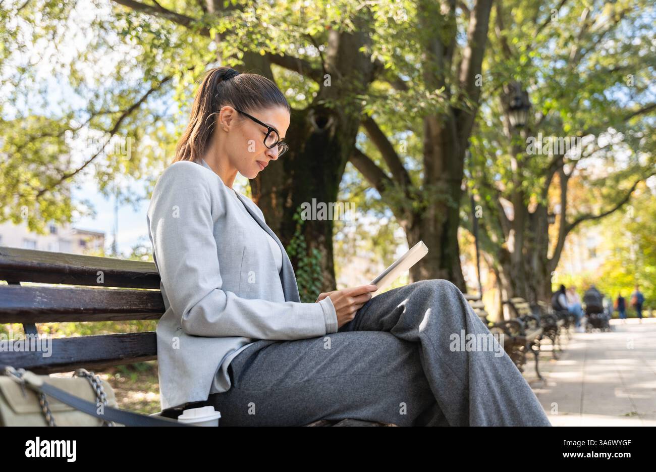 Successful confident businesswoman in formal wear sitting on bench ...