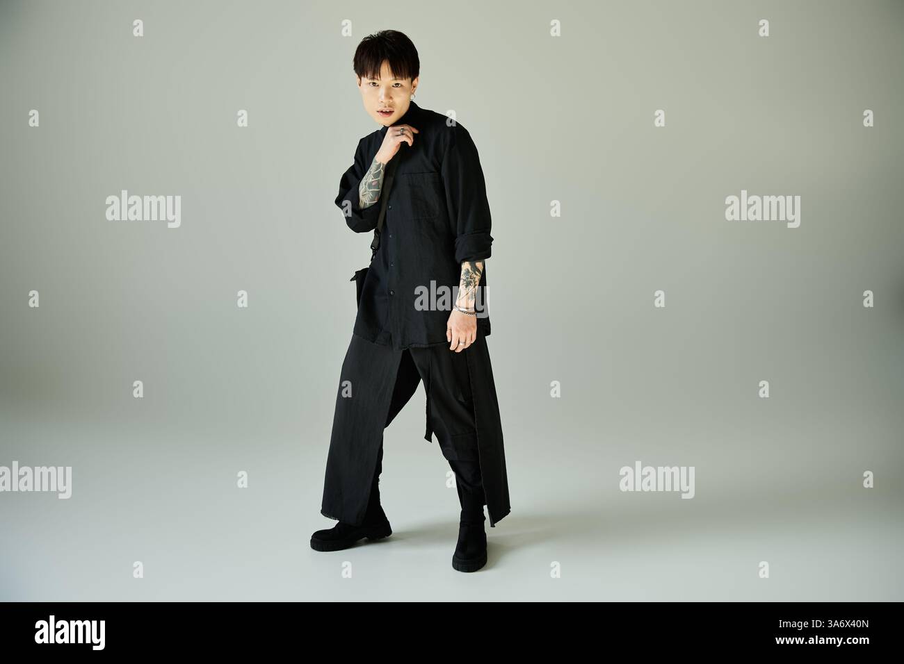 A stylish young man confidently shows off his outfit in a sleek setting ...