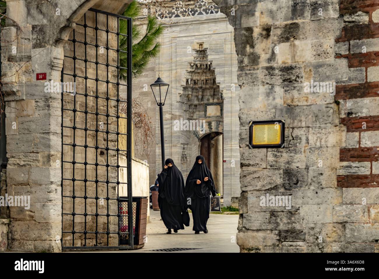Schwarz mit Niqab verschleierte Frauen an der Fatih Moschee in Fatih, Istanbul, Türkei  | Woman wearing plain-cloth black niqab at the Fatih Mosque in Stock Photo
