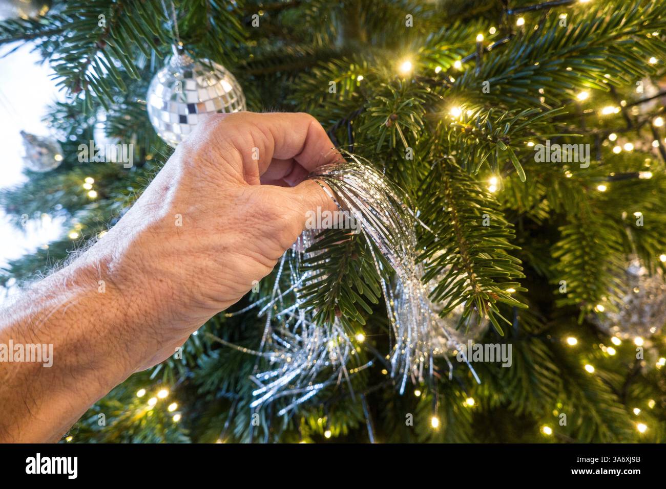 Christmas tree is decorated with silver tinsel, Germany Stock Photo
