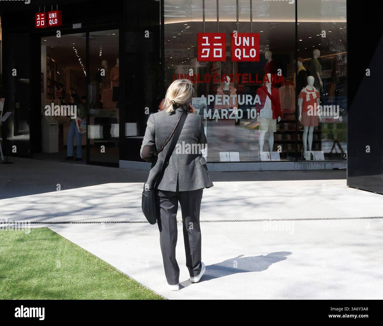 A woman walks past the window of Uniqlo's new flagship store in Madrid ...