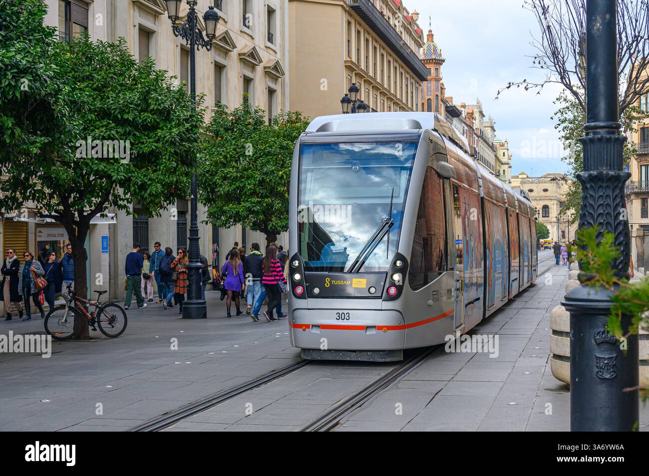 Modern public transportation tramcar driving past the medieval Seville Cathedral building, Seville, Spain Stock Photo