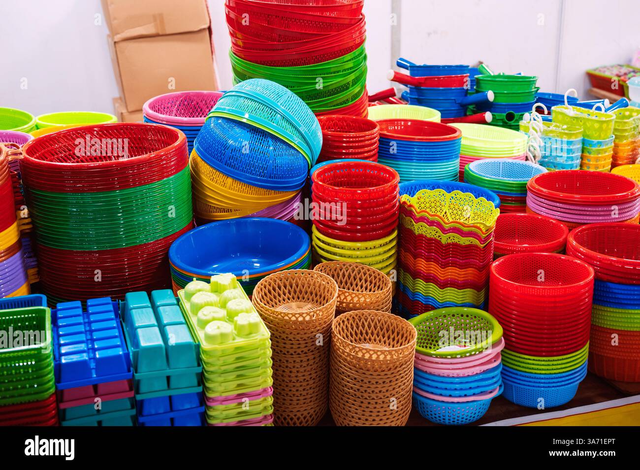 Close-up view of a vibrant stack of plastic bowls and baskets at a market. Stock Photo