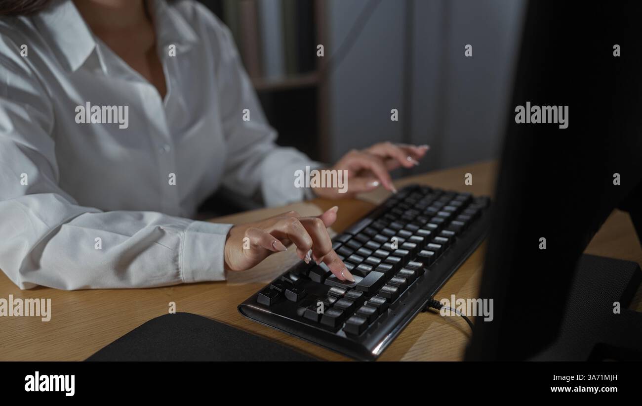 Woman typing on a computer keyboard at an office desk, engaging in work ...
