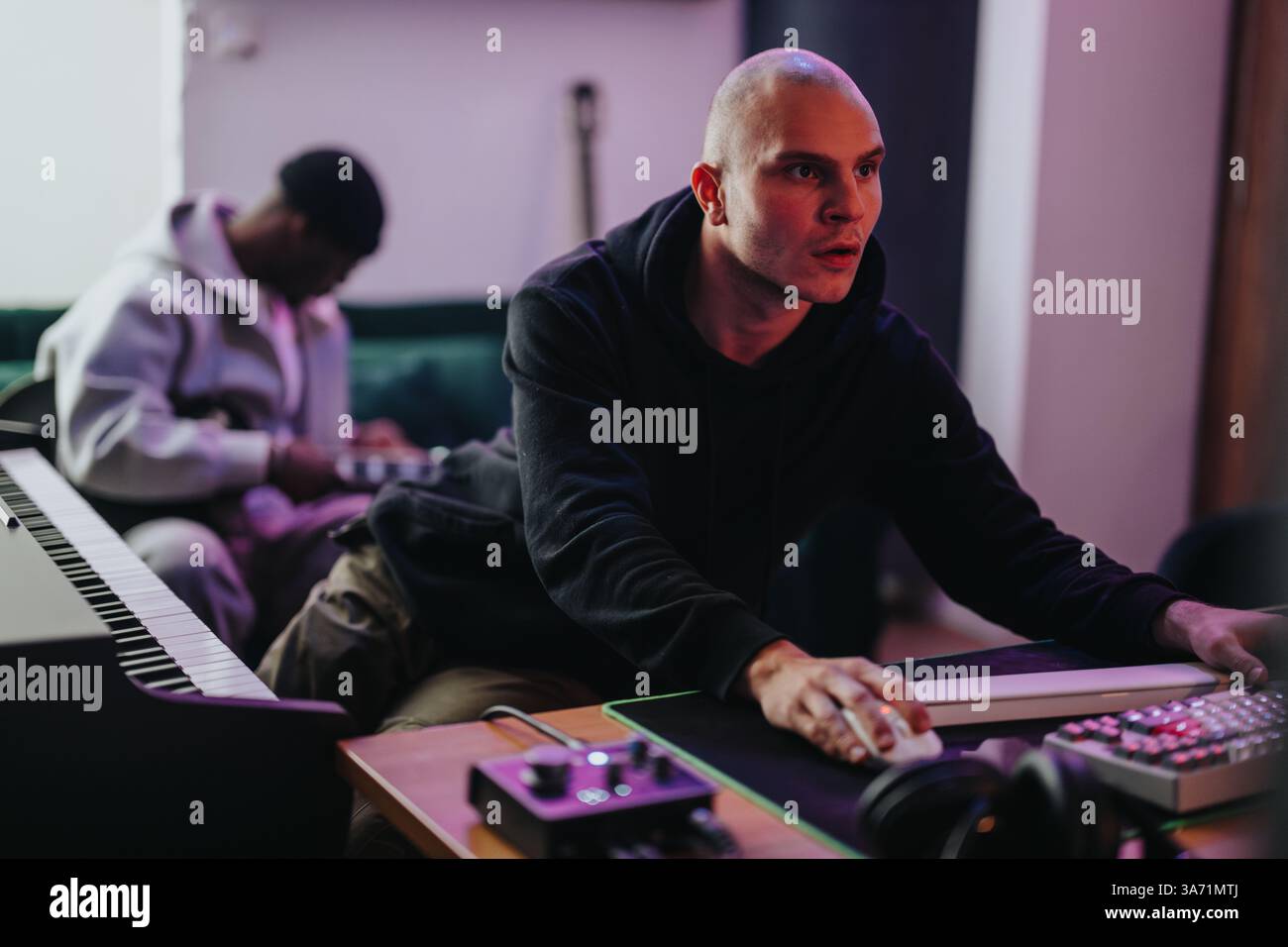 Two musicians collaborating in a modern music production studio setting ...
