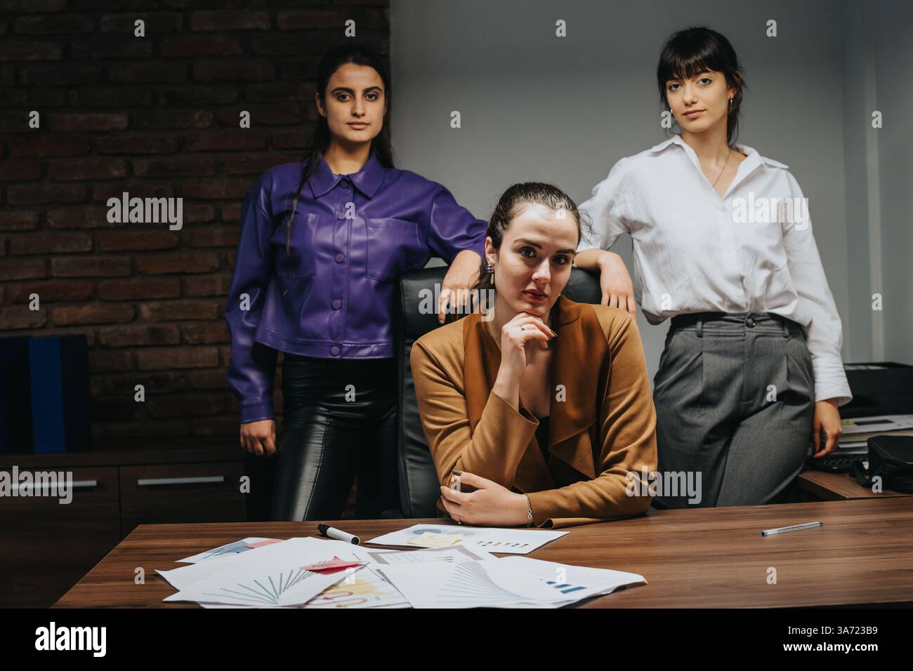 Confident team of three professionals collaborating in a modern office setting Stock Photo