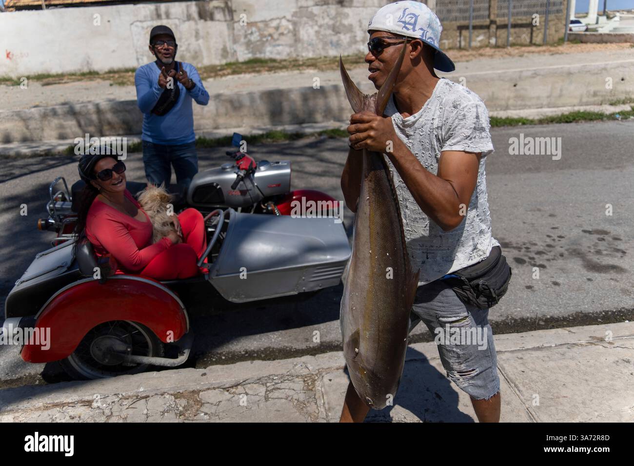 A fisherman carries his catch of the day after using a makeshift ...