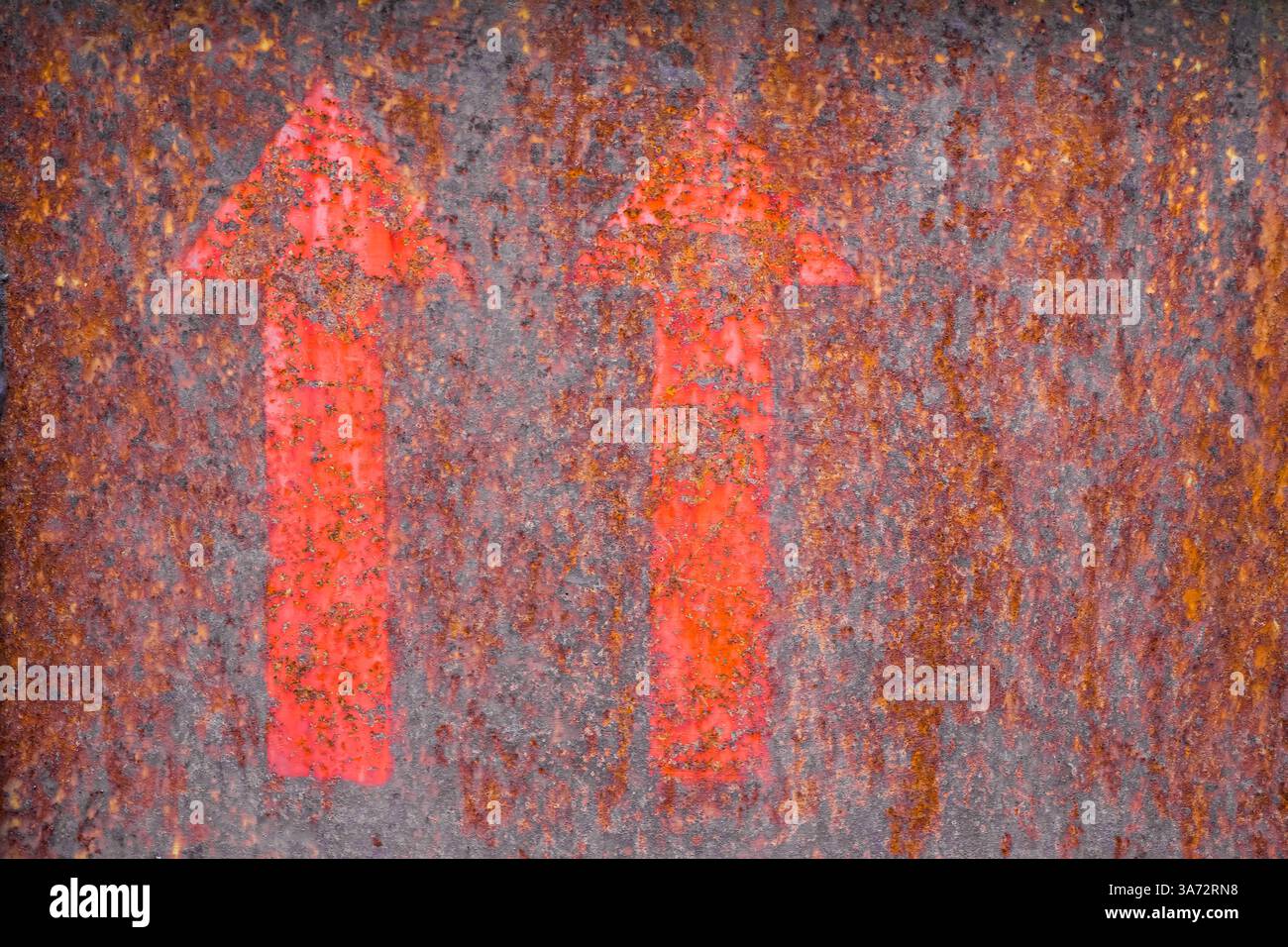 Rusty metallic background with two red arrows as a hint. Stock Photo