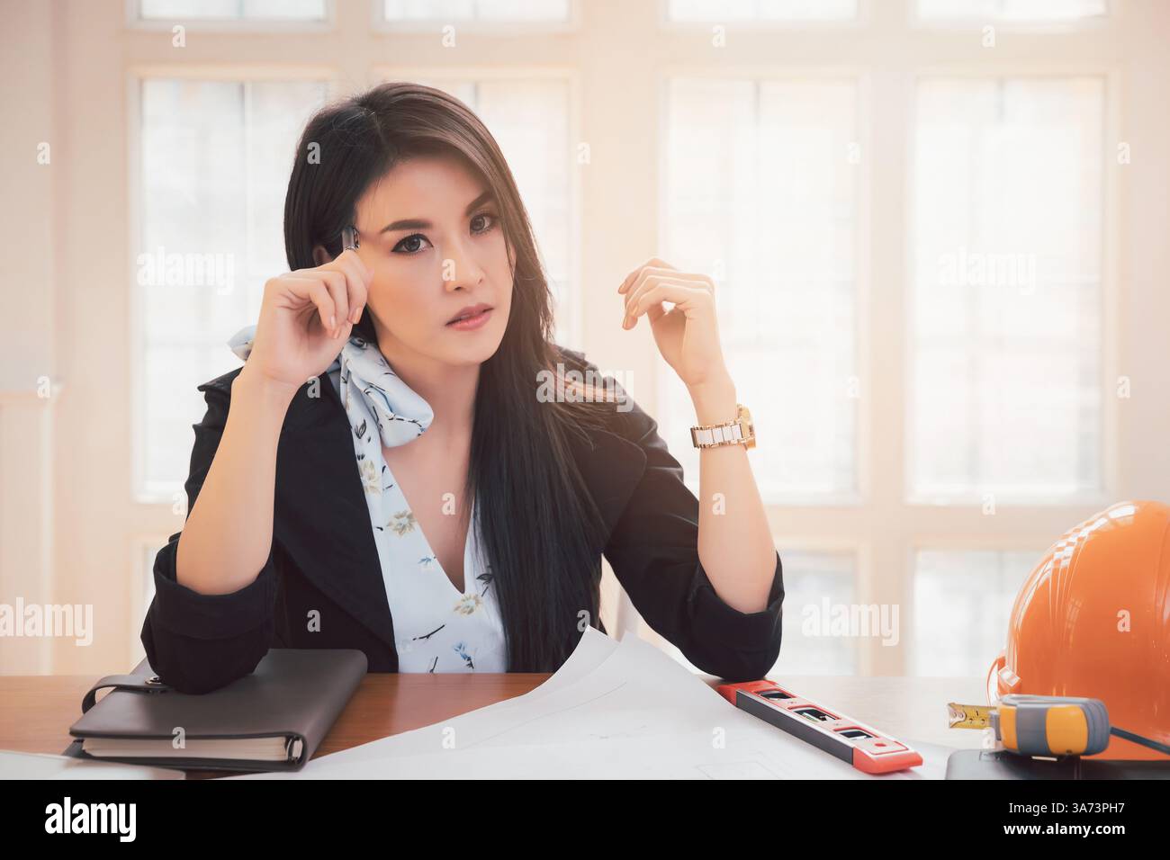 Female architect working on blueprint architects project in office. Stock Photo