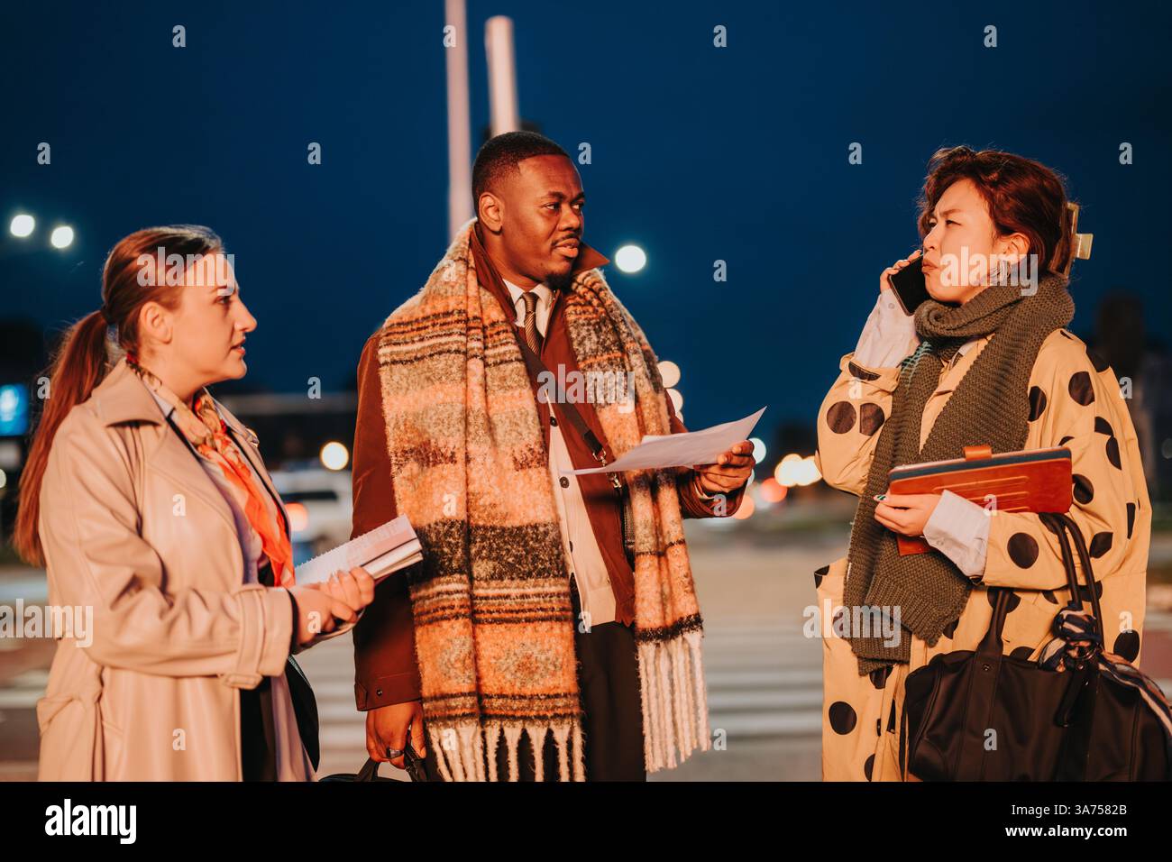 Multiracial business people collaborating outdoors during an evening meeting Stock Photo