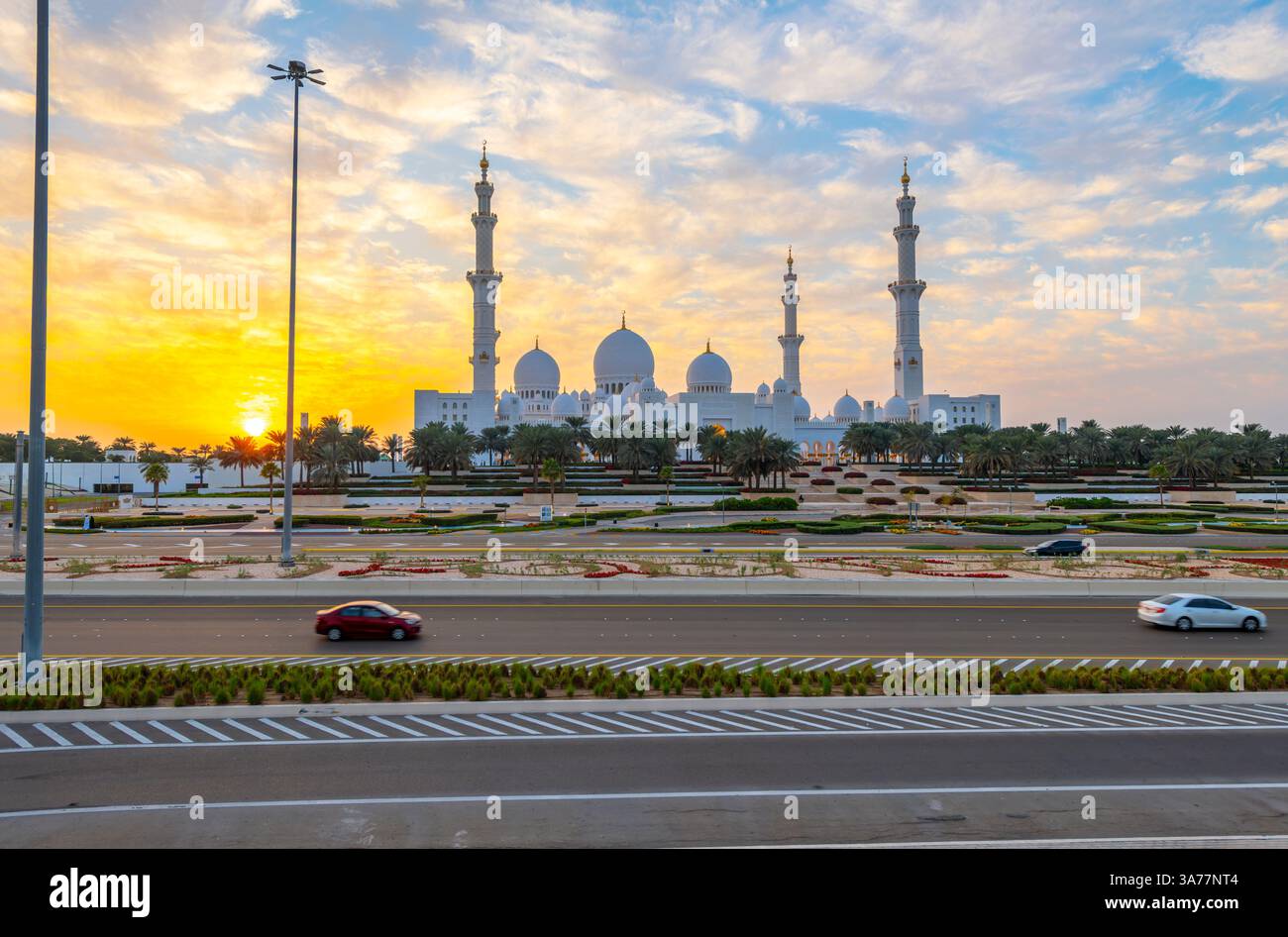 he facade and marble domes of the Sheikh Zayed Grand Mosque, the largest mosque in the UAE, as the sun sets behind, in Abu Dhabi UAE Stock Photo