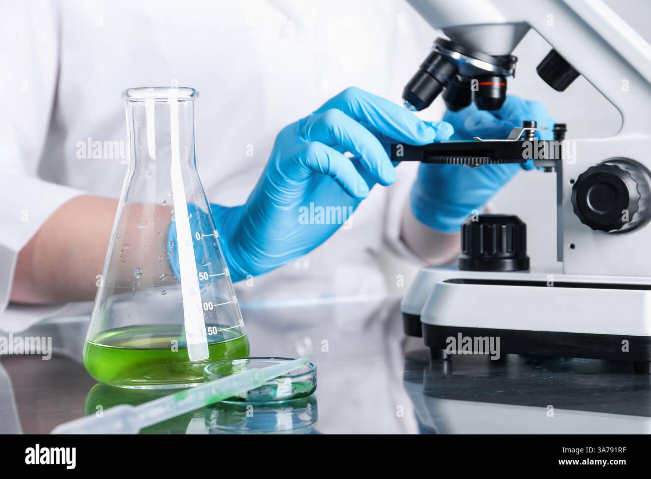 Laboratory testing. Scientist examining sample under microscope indoors ...