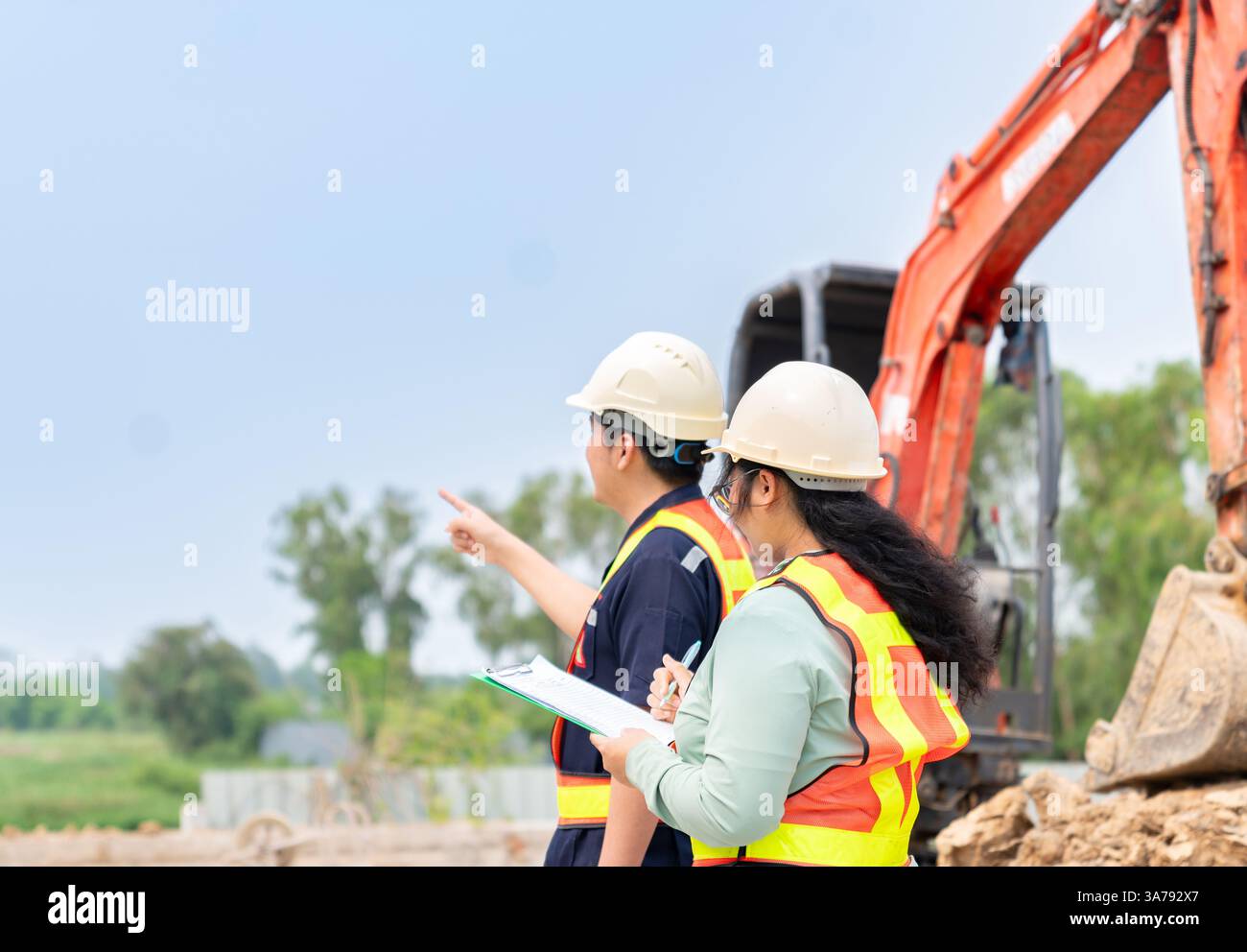 Civil engineer and foreman exemining the project at construction site ...