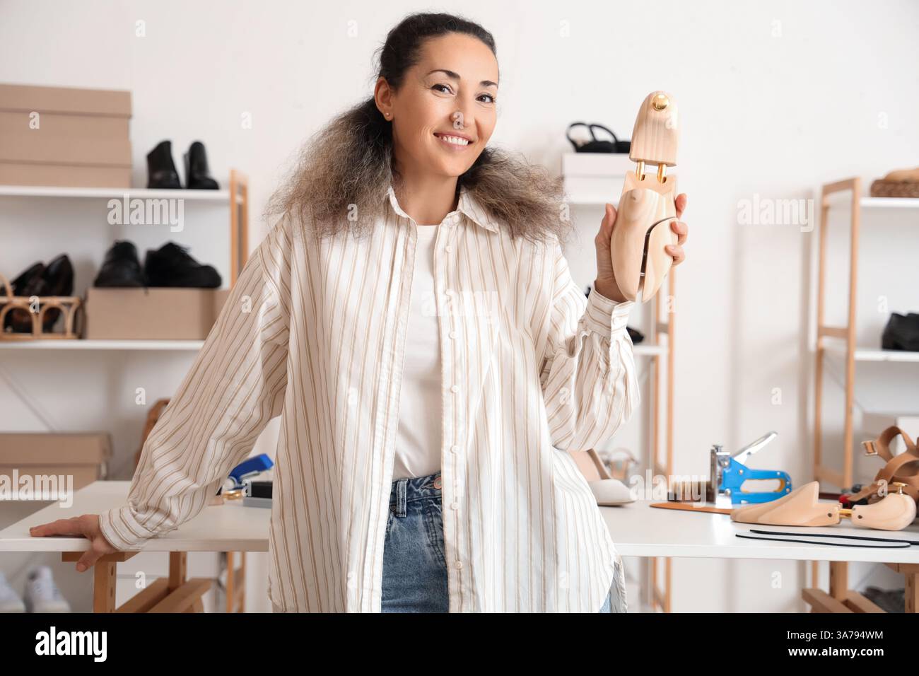 Female shoemaker with wooden shoe tree in workshop Stock Photo - Alamy