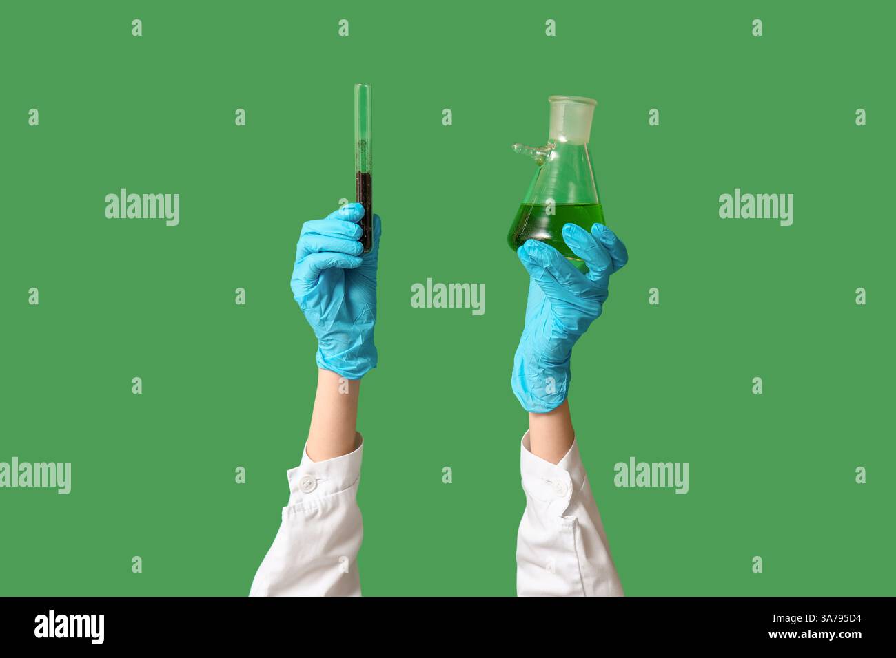 Scientist's hands holding test tubes with soil and green liquid on ...