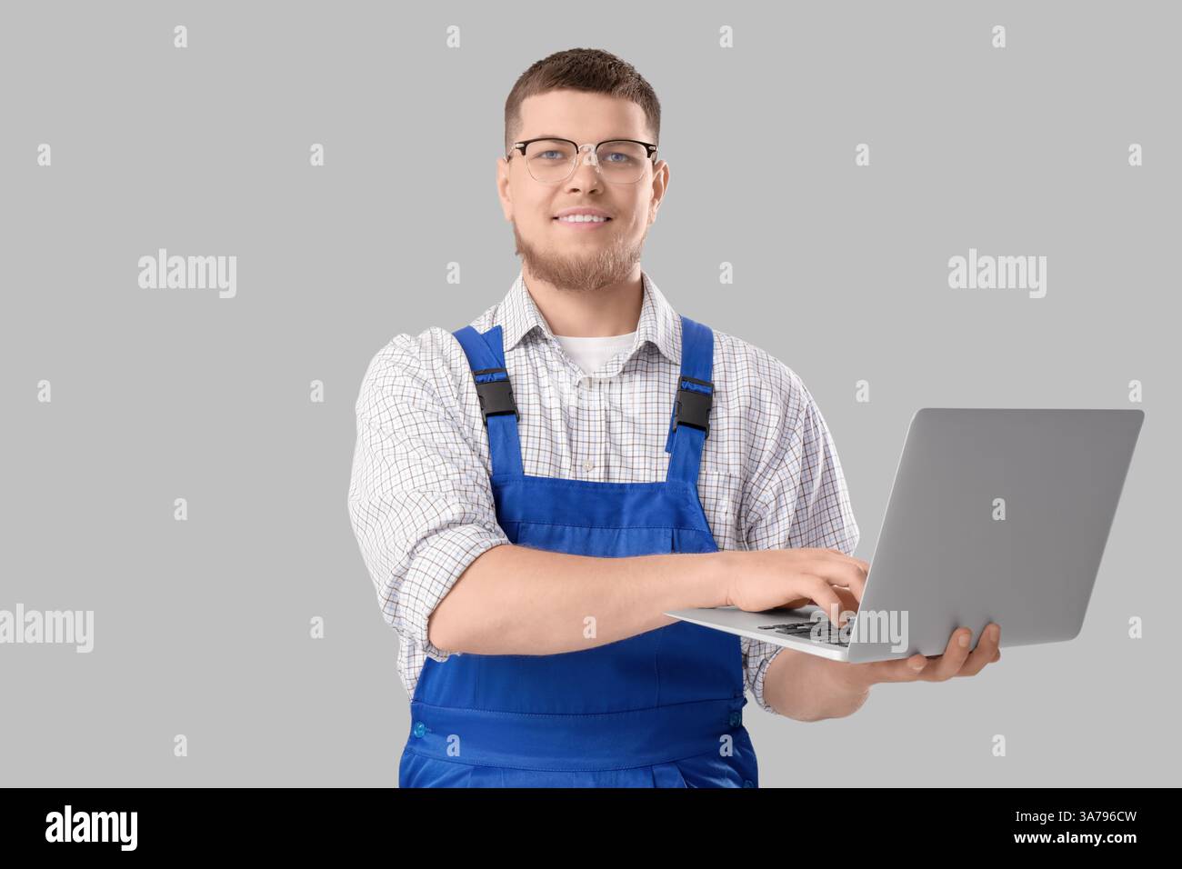 Male contractor using laptop on light background Stock Photo