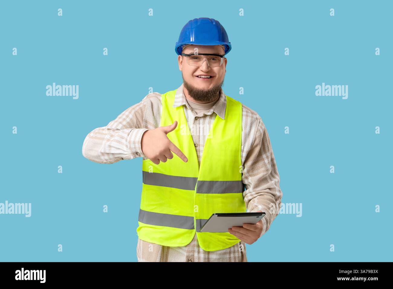 Male engineer with tablet computer on blue background Stock Photo