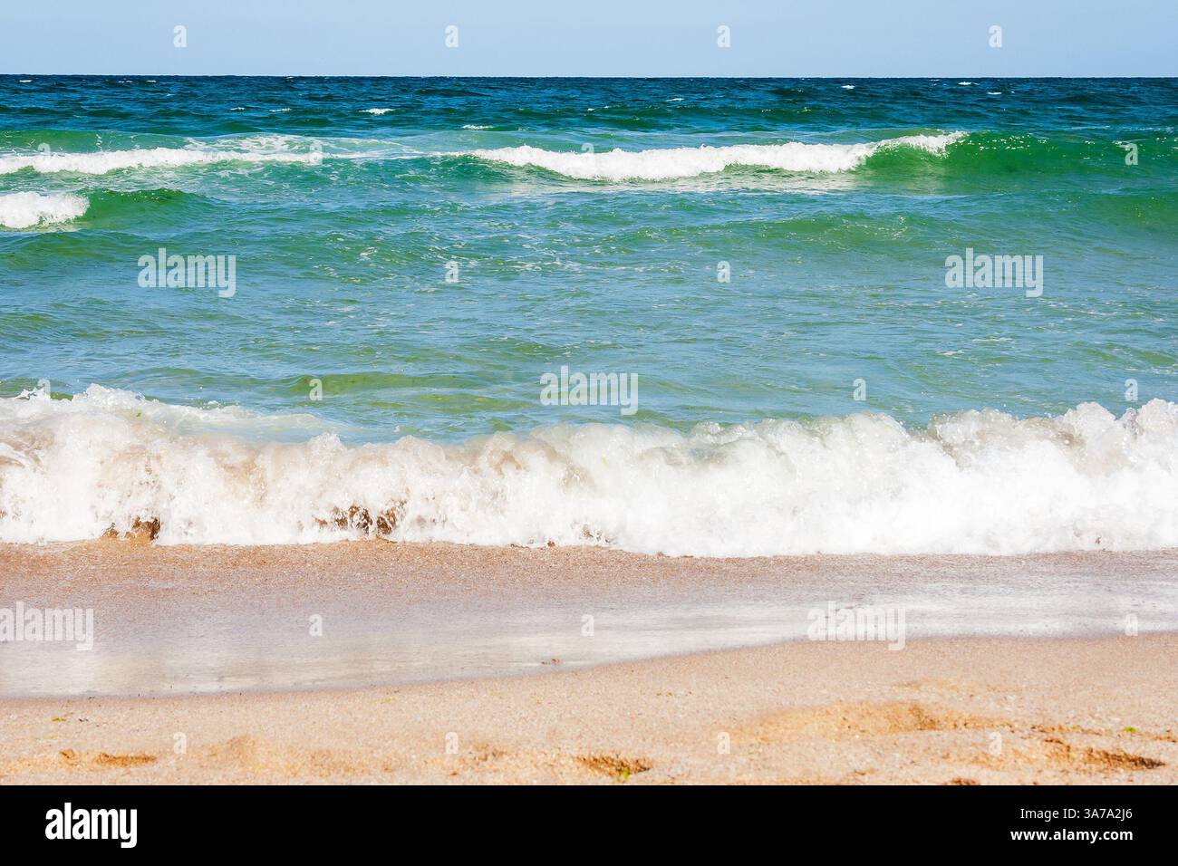 sea scenery in summer. beach with golden sand. wonderful vacation background with transparent calm waves and blue sky. adventure at the sandy seaside Stock Photo