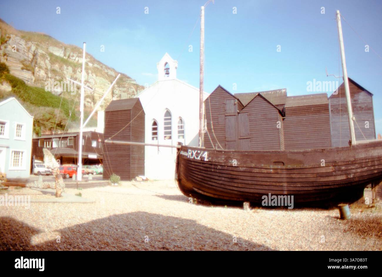 Historic black wooden net huts and an old fishing boat (RX74) on the ...