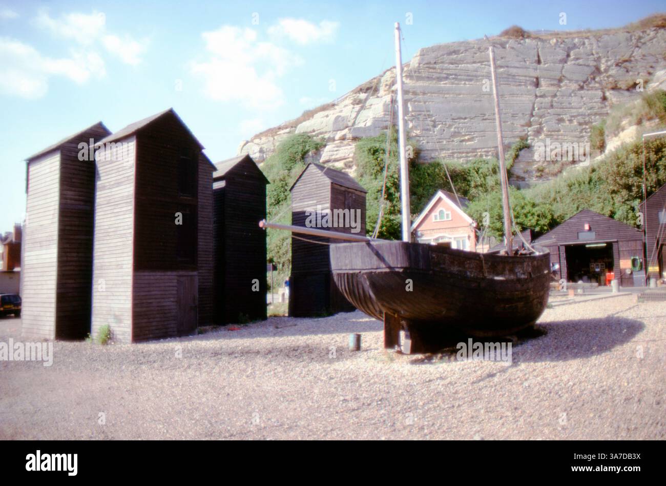 Historic black wooden net huts and an old fishing boat (RX74) on the ...