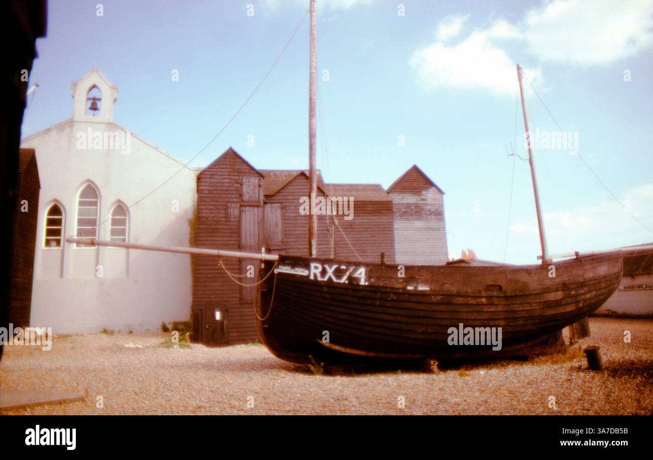 Historic black wooden net huts and an old fishing boat (RX74) on the ...