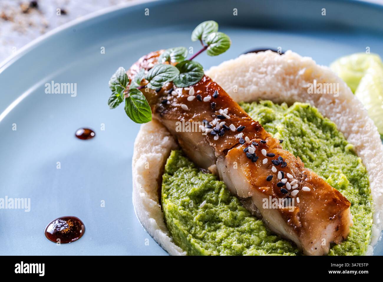 Cod Fillets Broccoli Cod fillet with spinach and broccoli puree and cauliflower on a blue ...