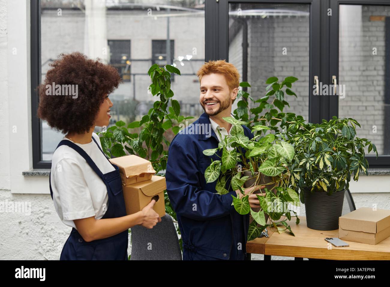 Two Organize Two people joyfully organize plants and boxes, embracing their new ...