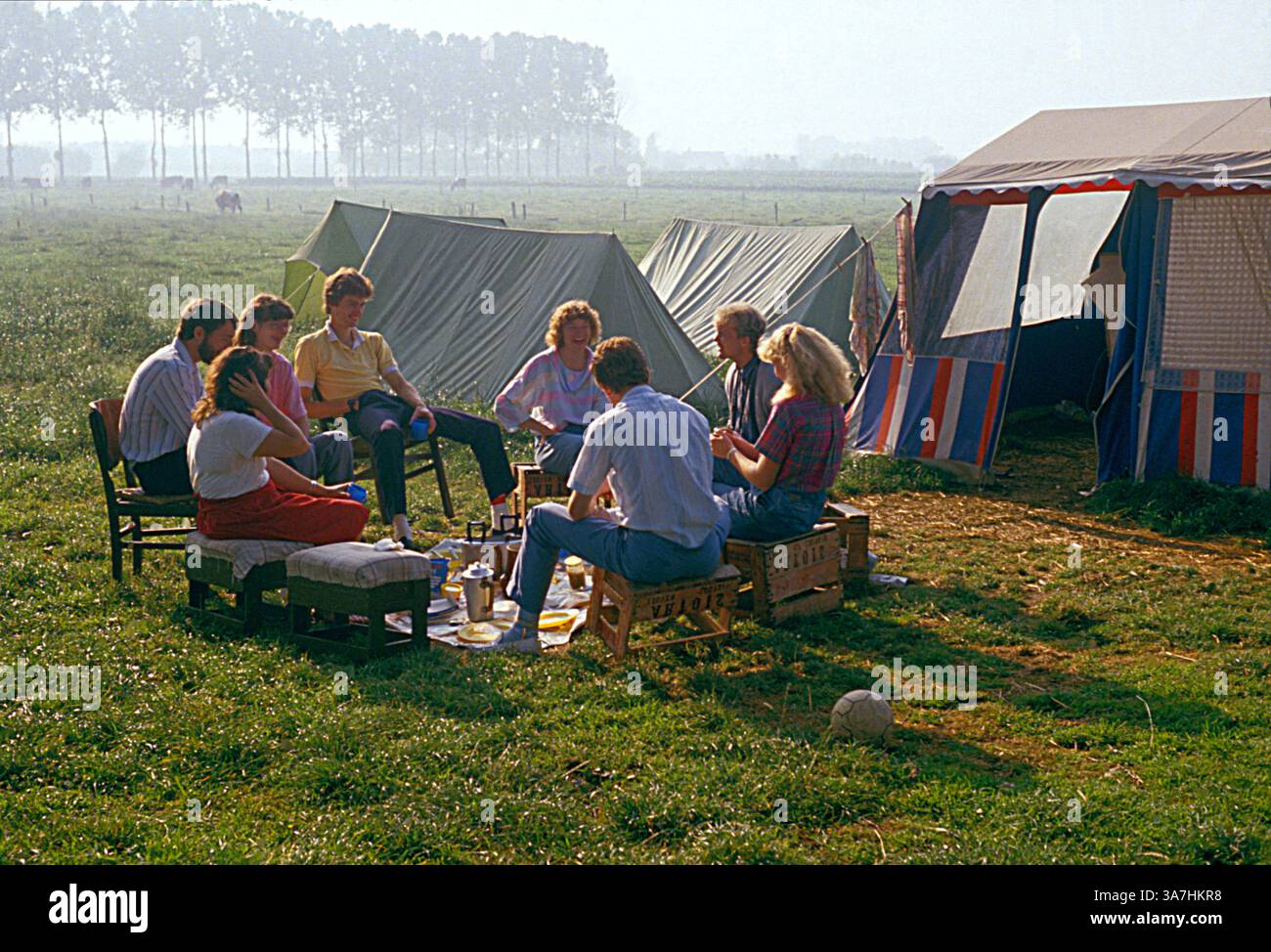 France. Group of young people sitting by tents outdoors. Camping. Stock Photo